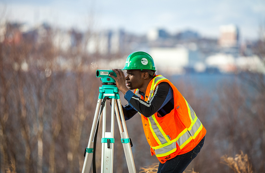 A Civil Engineering Technology student practicing their skills outdoors.