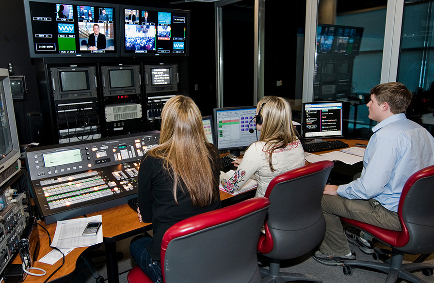 Radio Television Arts students in front of monitors and tools related to their studies.