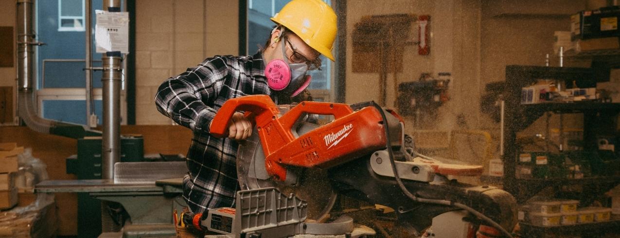 An NSCC carpentry student works with power tools in a carpentry shop in Akerley Campus.