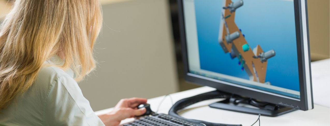 A woman uses engineering CAD technology while using a computer.