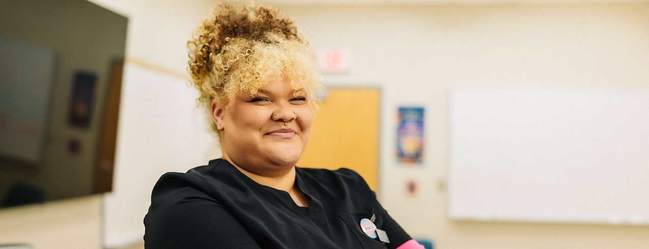 An NSCC Continuing Care graduate smiles while looking over her right shoulder.