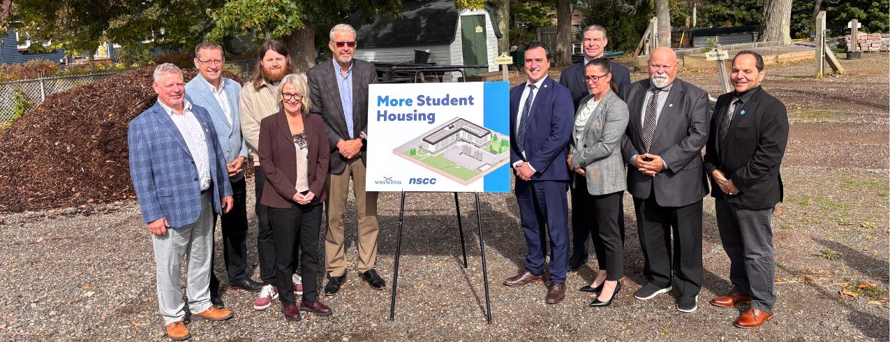 Image of ten individuals from NSCC Kingstec Campus and the Nova Scotia Government standing in front of the future home of new student housing at Kingstec Campus.