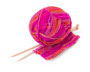 A ball of yarn and a partially-knit scarf with knitting needles.