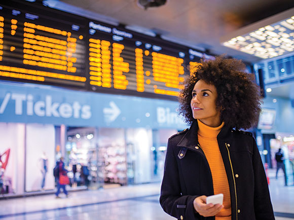 A woman holds a phone in an airport.