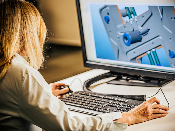 A person sits at a desk and uses a computer.