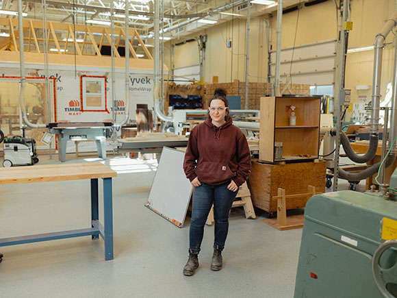 A student stands in a carpentry shop at NSCC.