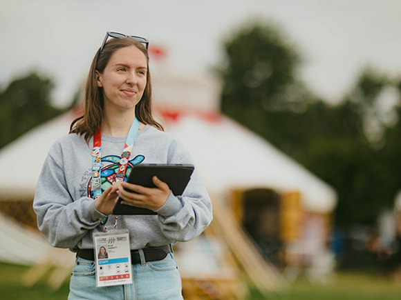 A young woman, Ellie Parrott, working with a clipboard at an event.