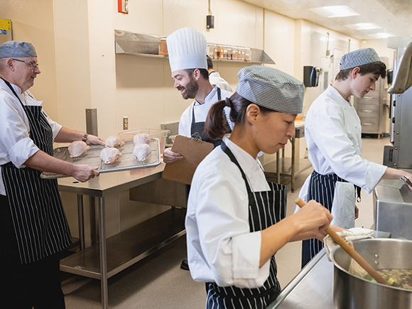 A group of students preparing meals together in a kitchen.