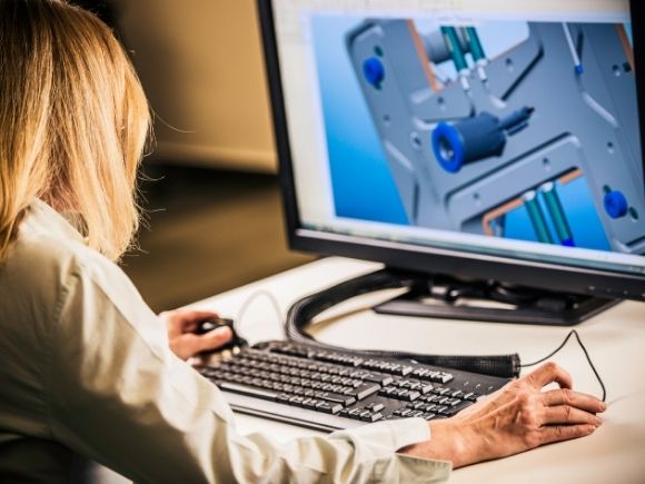 A student works on a desktop computer using design software.