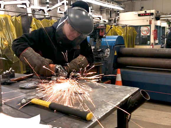A welder works in a welding shop.