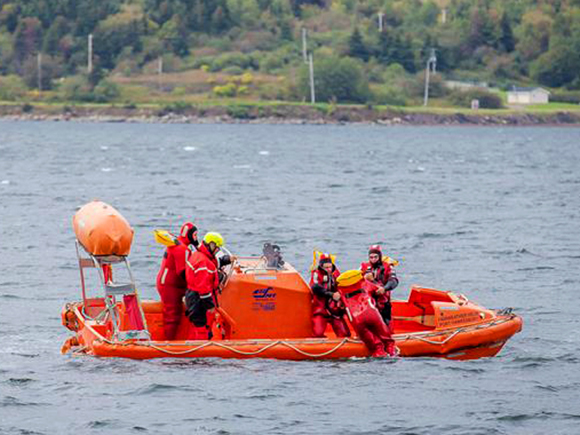 Five people participate in an on-water rescue exercise.