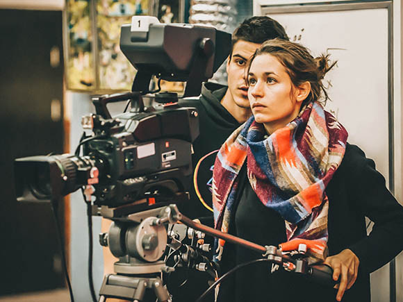 A videographer sets up a TV camera.