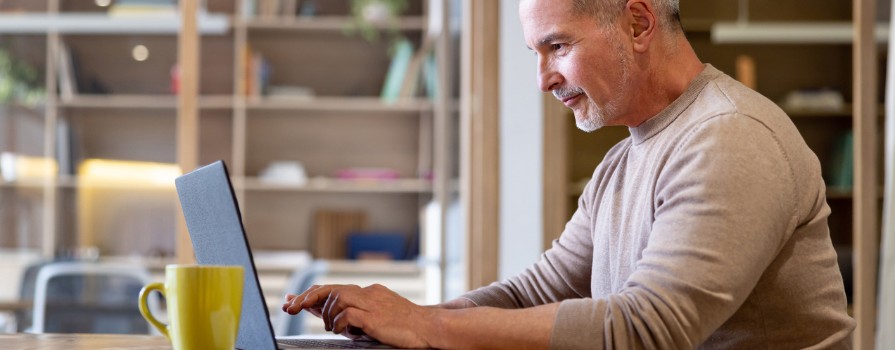 A middle-aged man working on his laptop.