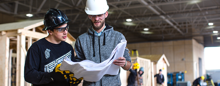 Two construction workers reviewing blue print plans.