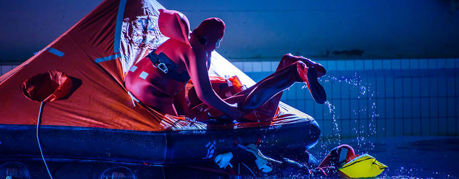 students conducting a mock rescue in a pool with a life raft