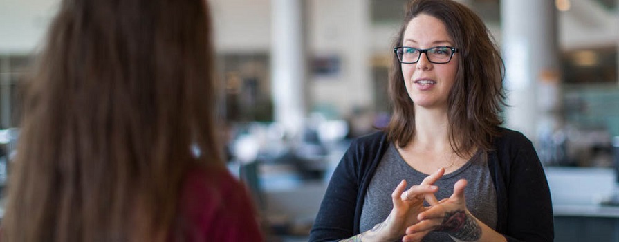 People converse at NSCC using American Sign Language.