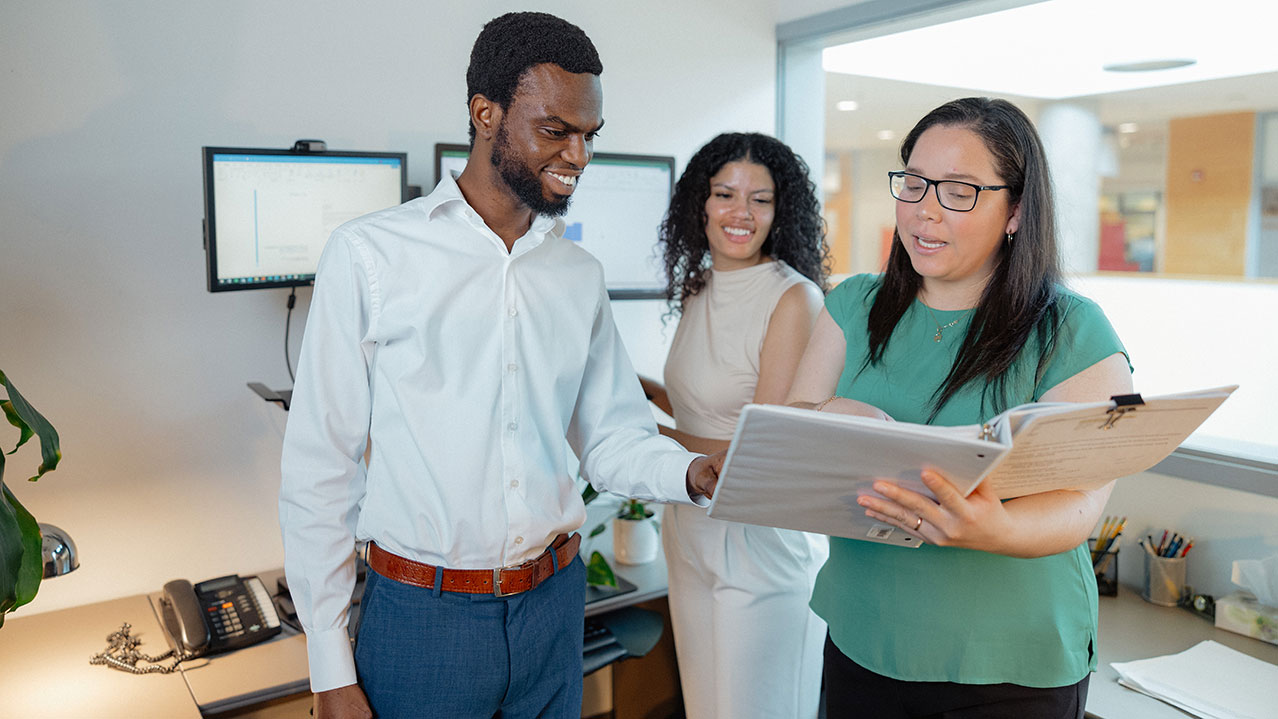 Three NSCC grads work together in an office environment.