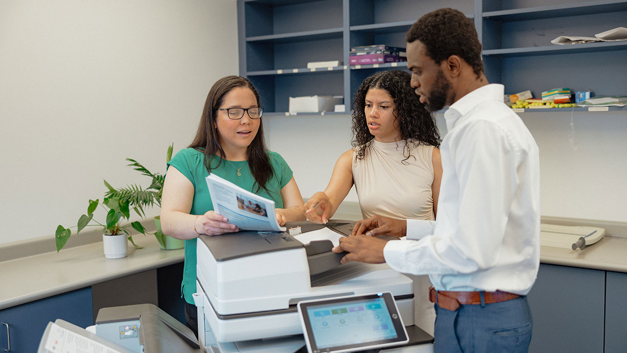 Three NSCC grads collaborating on administrative work.