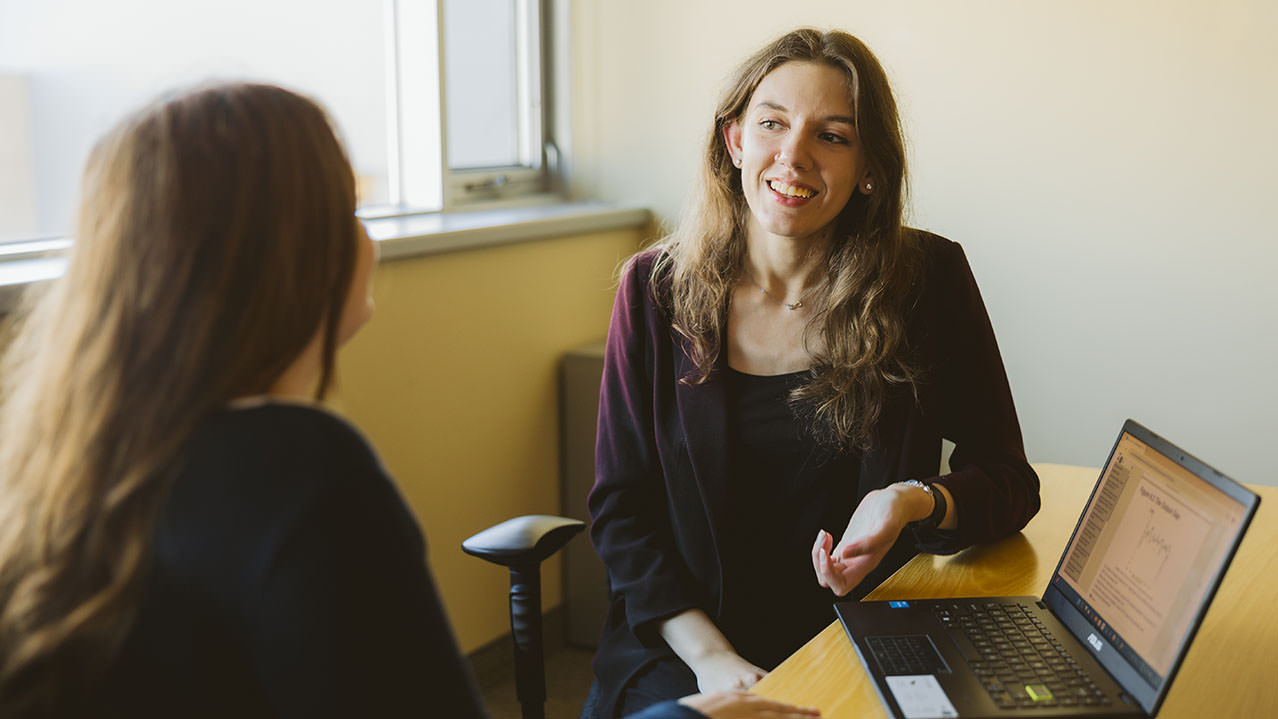 Two Nova Scotia Business Administration program students sit at a table and talk.
