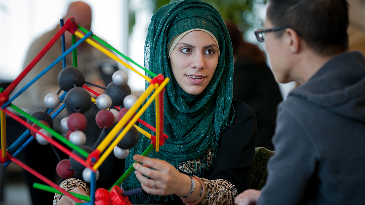 A woman and a man sit a table together and have a conversation.
