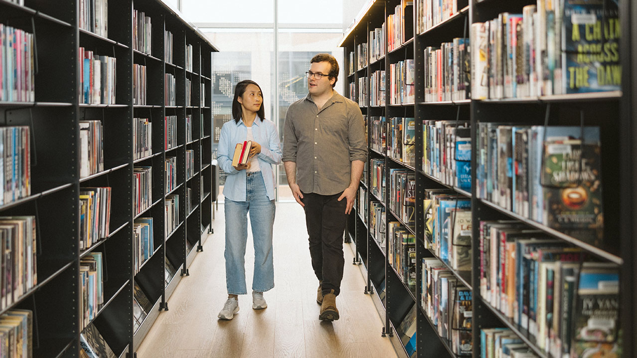 Two NSCC Library and Information Technology students walk through a library.