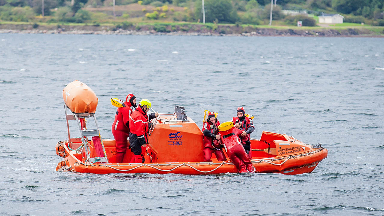 Five people participate in an on-water rescue exercise.