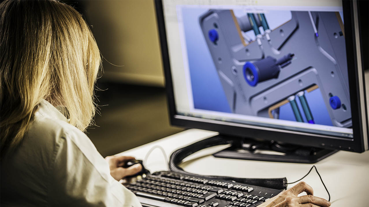 A student works on a desktop computer using design software.