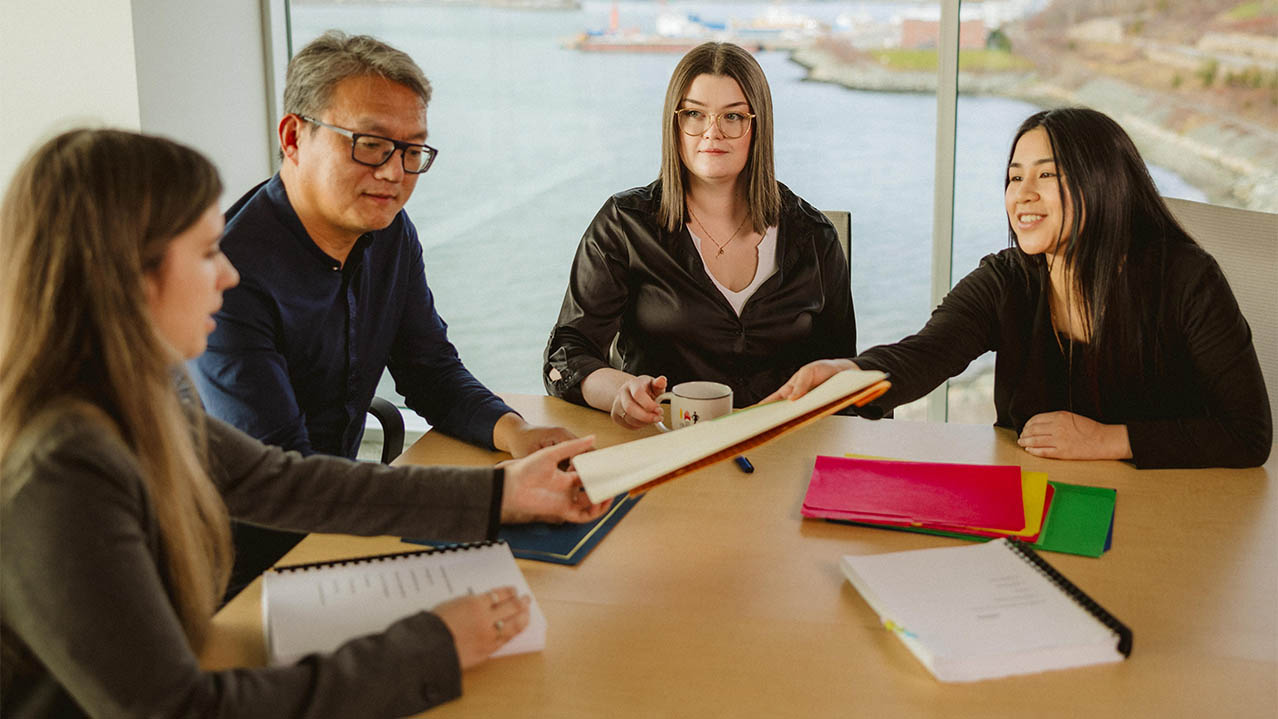 A group of NSCC Paralegal Services students sit around a table and discuss a class project at Ivany Campus.