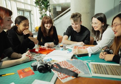 A group of students work together at a table at an NSCC campus.
