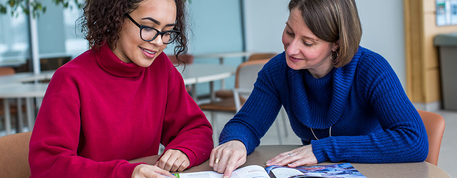 A female advisor working with a student.