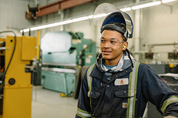 NSCC Metal Fabrication student, Dekai is seen in his work coveralls in the workshop.