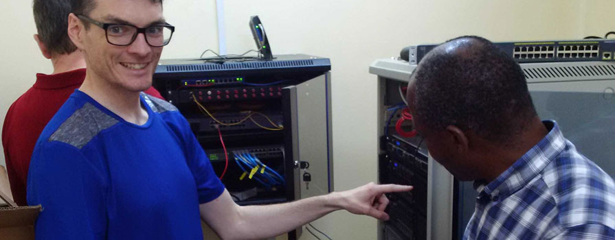 People posing close to a piece of equipment