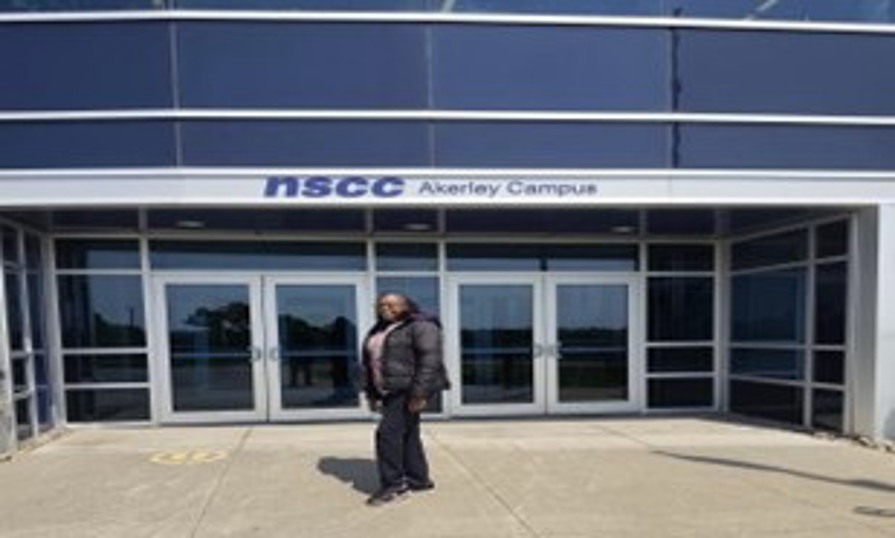 Josephine standing in front of NSCC Akerley Campus entrance doors.