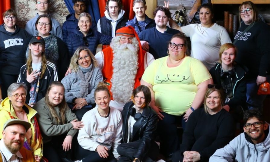 Kaylyn and a group of BIDS Inclusion participants in Finland smiling with Santa Claus, on an unforgettable journey of growth, support, and inclusion.
