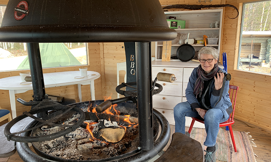 Janet sitting close to a firepit