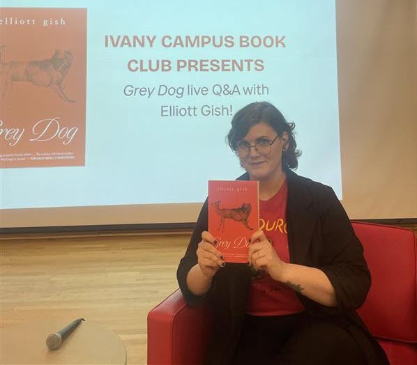 Author Elliott Gish holds up a copy of her book Grey Dog. 