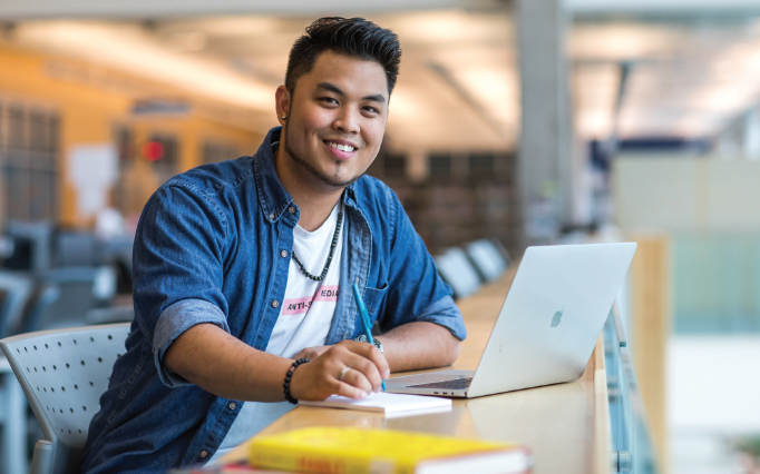 student working on laptop in library