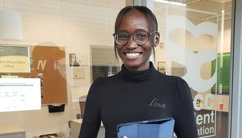 NSCC student Ribi stands outside the Student Association office at an NSCC campus.
